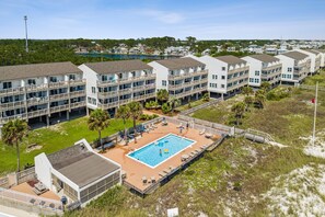 Un hôtel situé en bord de mer, doté de nombreux balcons, d’une piscine et d’une plage de sable.