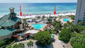 A resort with a pool, beach, and a tall building in the background. - True 1 BR with full kitchen, Luau 6532 by Skis and Seas | South Gulf facing (Destin)