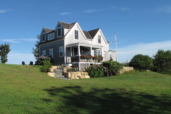 Our cottage sits perched on a hilltop surrounded by lush plantings and the sea.