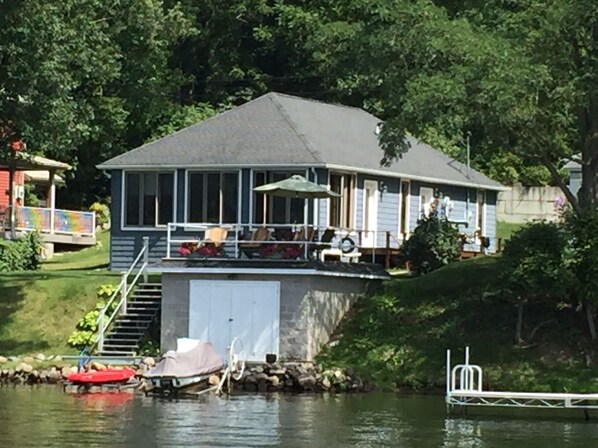 Relax on the covered deck with outdoor seating and enjoy the serene surroundings.