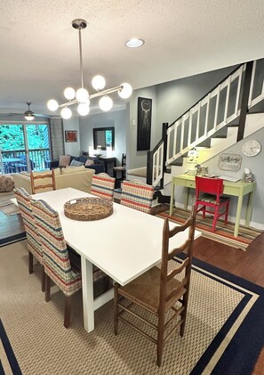 A dining area with a white table, striped chairs, and a ceiling light fixture. - Refreshed for 2026: 3BR Rehoboth Beach Townhome (Rehoboth Beach)