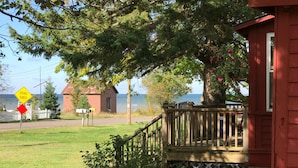 Une terrasse en bois avec vue sur la mer, un panneau indiquant la fin de la route et une boîte aux lettres.