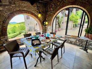 Enjoy a meal under the stars in this charming outdoor dining area with a lush garden view.