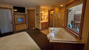 Une salle de bain d’hôtel avec une grande baignoire, une douche, un lavabo et un téléviseur dans un coin.