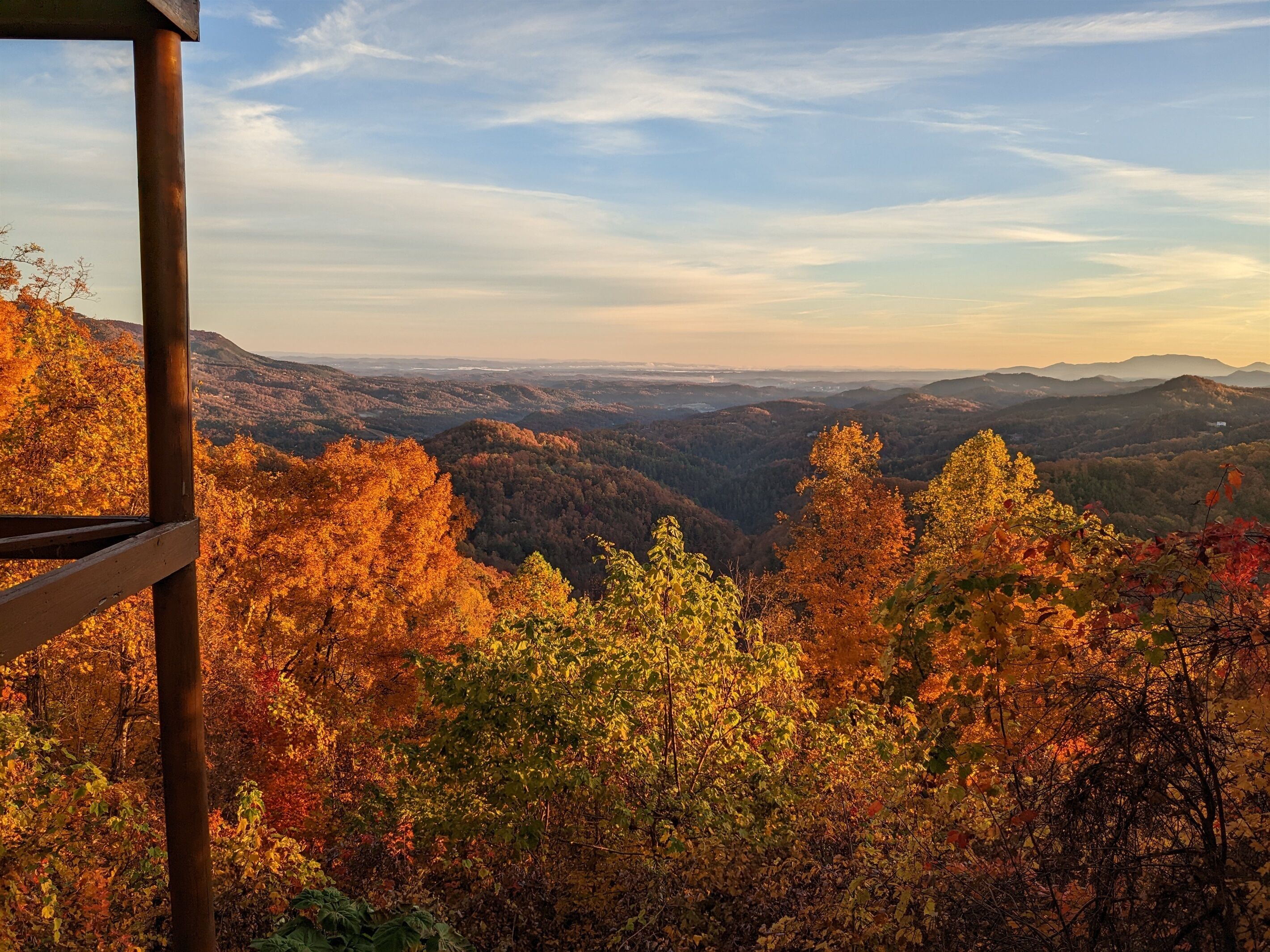 A panoramic view of a mountainous landscape with autumn foliage.