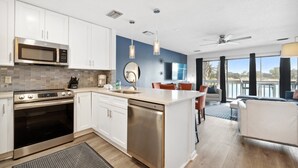 A modern kitchen with white cabinets, stainless steel appliances, and a large island. - 2 STORY WITH 2 PRIVATE BALCONIES! 150 STEPS FROM BEACH! (Miramar Beach)