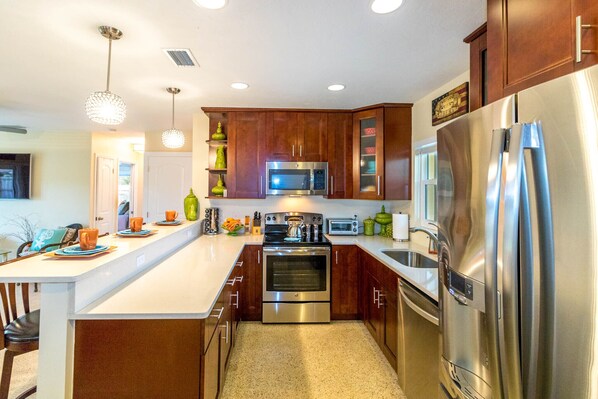 A modern kitchen with wooden cabinets, stainless steel appliances, and pendant lighting. - Arlington Park  Amazing Location   Pet Friendly  2 Master Suites Home (Sarasota)