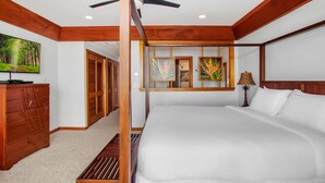 A spacious bedroom with a large bed, wooden headboard, ceiling fan, and artwork on the wall. - Poipu Kapili 54 - Air Conditioned OCEANFRONT Townhome - Can't beat our views (Koloa)