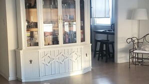 A spacious living area with a large white cabinet, a dining table, and a kitchen area in the background. - August 22-29 Available Due to Cancellation!!! Accepting bookings for Summer 2027 (Beach Haven)