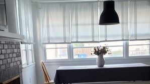 A spacious room with a large window, a fireplace, a dining table with a bench, and a hanging light fixture. - August 22-29 Available Due to Cancellation!!! Accepting bookings for Summer 2027 (Beach Haven)