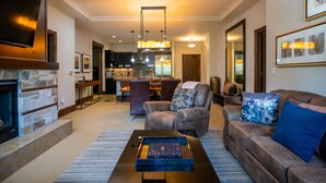 A modern living room with a fireplace, leather sofa, and a coffee table.