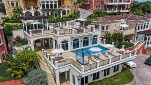 Un immeuble à plusieurs étages doté d’une piscine sur le toit, d’un espace extérieur aménagé et d’un patio couvert.