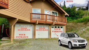 A two-story house with a private suite, a gated entrance, and a parked car. - Best Views in Anchorage! Totally Private, Romantic, and Family Friendly Suite! (Anchorage)