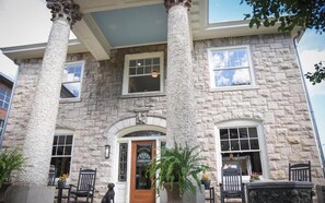 Un edificio de piedra con puerta de madera, columnas y ventanas.