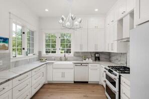 Enjoy cooking in this well-equipped kitchen with a dishwasher and large window offering a view of the surrounding greenery.