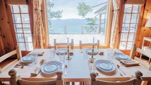 A wooden dining table set for six with a view of the sea. - Peaceful Lakefront Home with Gorgeous Lakeviews and Hottub, Lake St. Lakefront by Tahoe Time VR (Kings Beach)