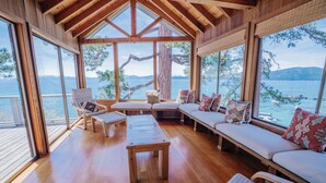 A wooden interior with large windows, a wooden bench, a sofa, and a table. - Peaceful Lakefront Home with Gorgeous Lakeviews and Hottub, Lake St. Lakefront by Tahoe Time VR (Kings Beach)