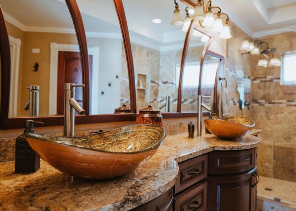 Une salle de bain moderne avec un grand lavabo ovale, un miroir et un luminaire placé au-dessus du lavabo.