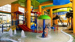Ein großer Wasserpark mit Wasserrutsche, Spielbereich für Kinder und überdachtem Sitzbereich.
