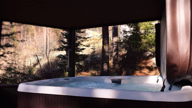 A hot tub with a view of a forested area. - Whitefish Mountain Resort, Ski In Ski Out Condo, 3 Bed 2 Bath, Private Hot Tub! (Whitefish)