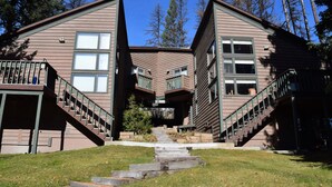 A modern house with a unique architectural design, featuring two symmetrical wings connected by a central section. - Whitefish Mountain Resort, Ski In Ski Out Condo, 3 Bed 2 Bath, Private Hot Tub! (Whitefish)