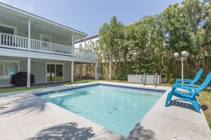Ett tvåvåningshus med en swimmingpool och en täckt uteplats.