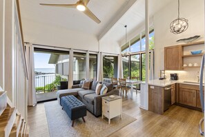 Relax in this spacious living area with a large sofa and ottoman, overlooking the ocean from the balcony.