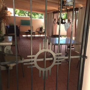Relax in a charming patio area with a metal gate, brick floor, and comfortable seating.
