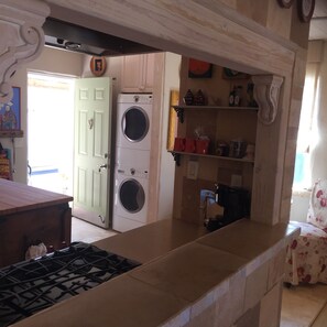 Kitchen area with washer and dryer, gas stove, and countertop.