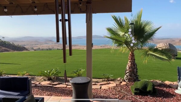 A patio with a view of a green field and mountains. - Highest reviewed property in the area - best view of  your life! (Lake Mathews)
