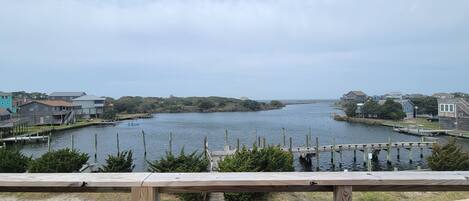 Une vue sur le front de mer, avec une terrasse en bois, une rivière paisible et des bâtiments en arrière-plan.