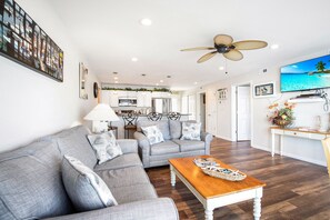 Relax in this spacious living area with a comfortable sofa, coffee table, and flat-screen TV.