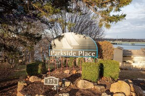 Surrounded by trees and shrubs, Parkside Place offers a serene environment with a bridge and building in the background.