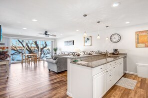 Enjoy cooking in this well-lit kitchen with a large island, sink, and a view of the outdoors.