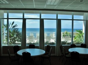 Enjoy ocean views from the large windows, perfect for meetings or dining with round tables and chairs.