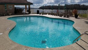 Una piscina con un puesto de socorrista y una zona de estar cubierta.