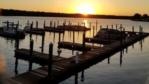 Un lago tranquilo al atardecer con muelles de madera y barcos.