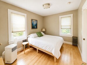 Un dormitorio con cama, un calentador independiente y ventana con persianas.