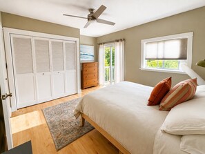 A bedroom with a bed, a ceiling fan, a wardrobe, a dresser, and a window with blinds. - Downtown home, large deck, short walk to the heart of Hood River! Pet Friendly! (Hood River)