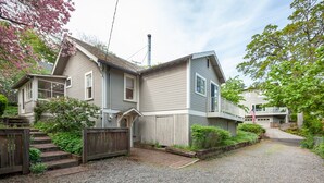 Et tosset hus med en veranda, skorsten og grusvej.