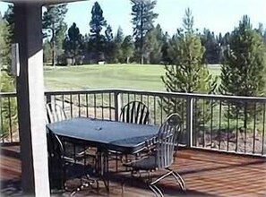 Relax on the patio with a table and four chairs, surrounded by a natural setting.