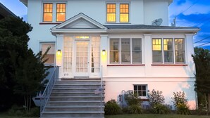 A two-story house with a front porch, a satellite dish, and a number '819' on the front door. - Short walk to the Beach, sleeps 8, four bedrooms, private patio, 2026 weeks open (Cape May)