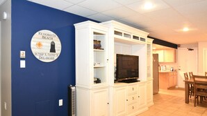 Olohuoneessa on sisäänrakennettu televisio, kirjahylly ja seinällä oleva kyltti, josta ilmenee, että paikka on Rehoboth Beach, Delaware.