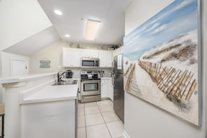 Enjoy cooking in this well-equipped kitchen with a sink, stove, microwave, and refrigerator.