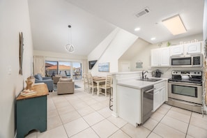 Enjoy a spacious kitchen, dining area, and living space with a balcony offering a view of the outside.