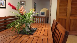 A wooden dining table with a potted plant in the center.