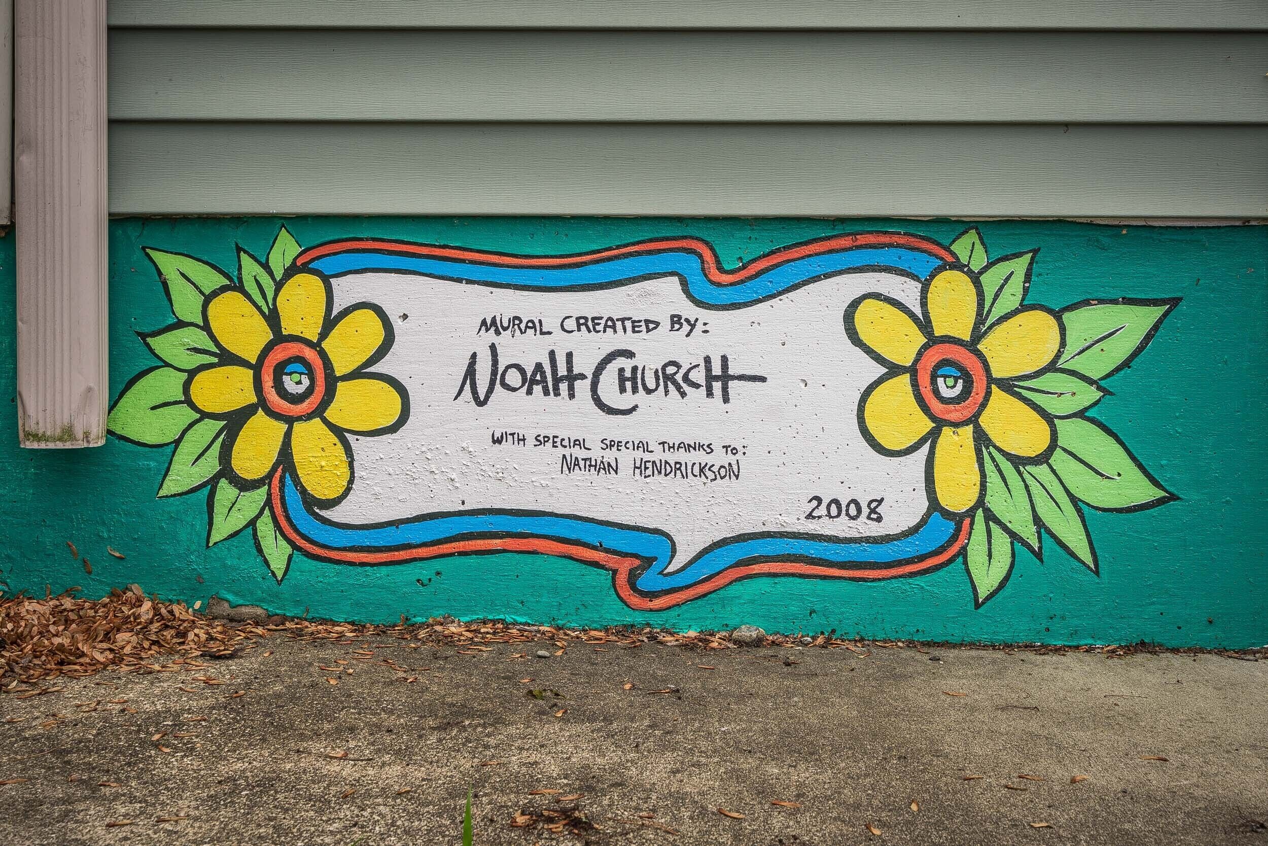 Une fresque murale représentant deux fleurs et un texte.