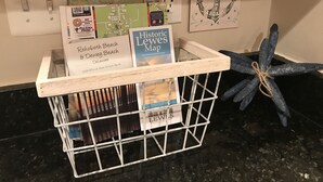 A wooden crate with a map, a guidebook, and a decorative anchor on a kitchen counter. -     🏖️ Check out our off season discounted rates.  (Lewes)