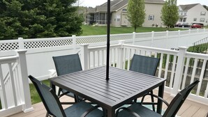 A deck with a table and chairs, surrounded by a white fence, overlooking a residential area. -     🏖️ Check out our off season discounted rates.  (Lewes)