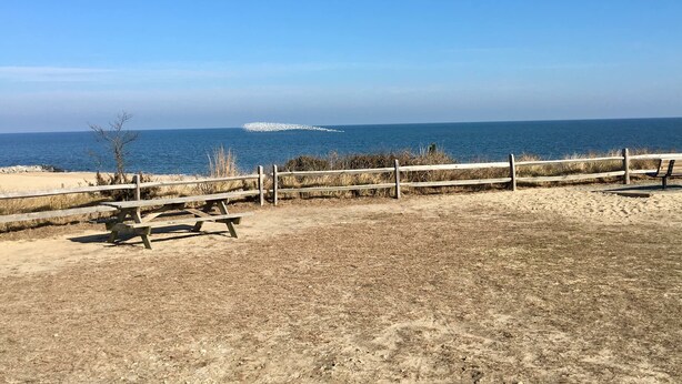A beach with a wooden fence, a picnic table, and a bench. -     🏖️ Check out our off season discounted rates.  (Lewes)